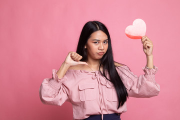 Asian woman thumbs down with red heart.