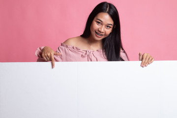 Young Asian woman point to a  blank sign.