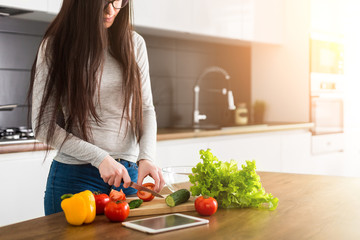 Young trendy woman cooking healthy food in the morning
