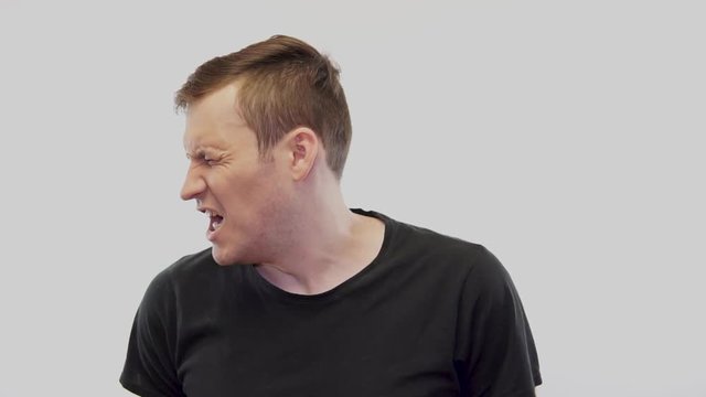 Crop person slapping scared man in face Emotional male getting slapped in face while shouting with closed eyes in fear on white background