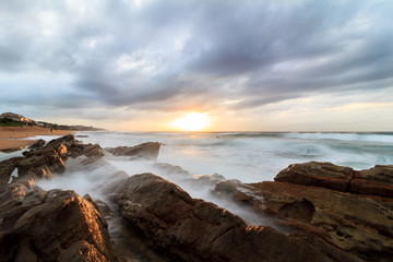Sunrise on rocky shoreline South Africa East coast