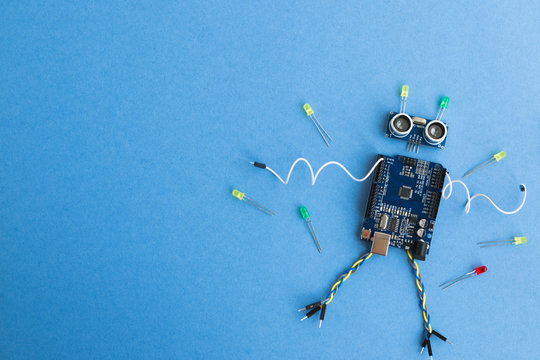Back to school concept. A metal robot and an electronic board that can be programmed. Robotics and electronics. DIY robotics. STEM and STEAM education for kids. Free space for text.