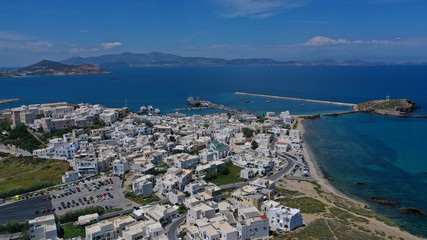 Naklejka premium Aerial drone photo of iconic port of Naxos island featuring uphill castle and beautiful Temple of Apollon or Gate, Cyclades, Greece
