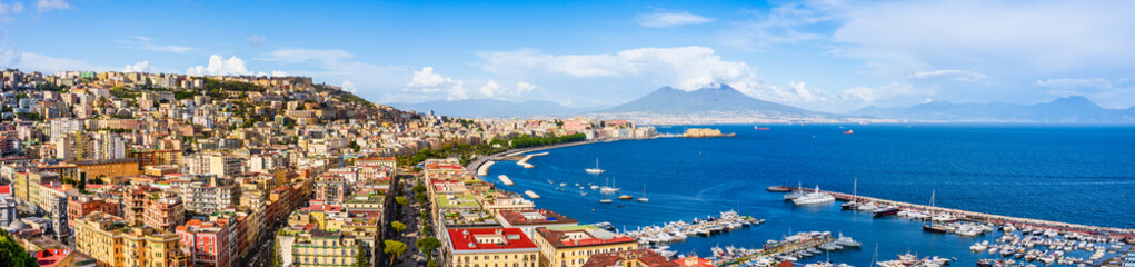 Fototapeta na wymiar Naples city and port with Mount Vesuvius on the horizon seen from the hills of Posilipo. SSeaside landscape of the city harbor and golf on the Tyrrhenian Sea