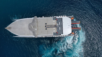 Aerial drone top view photo of high speed passenger ferry arriving at port of Mykonos island, Cyclades, Aegean sea, Greece © aerial-drone