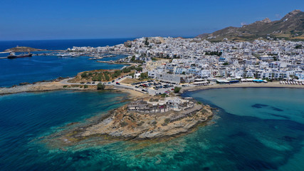 Aerial drone panoramic photo of famous turquoise sea sandy beach of Saint George next to chora main town of Naxos island with beautiful uphill castle, Cyclades, Greece