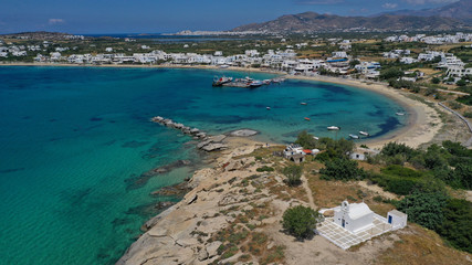 Naklejka na ściany i meble Aerial drone photo of breathtaking turquoise round sandy beach and small village and small seaside picturesque chapel of Agia Anna, Naxos island, Cyclades, Greece
