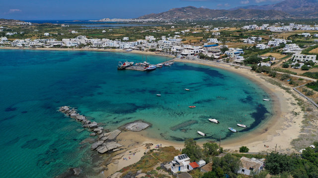 Aerial drone photo of breathtaking turquoise round sandy beach and small village and small seaside picturesque chapel of Agia Anna, Naxos island, Cyclades, Greece © aerial-drone