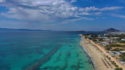 Fototapeta na wymiar Aerial drone top view photo of breathtaking turquoise sandy beach of Plaka with sun beds and umbrellas, Naxos island, Cyclades, Greece