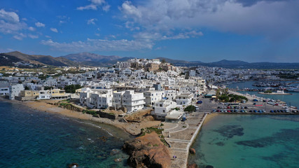 Fototapeta premium Aerial drone photo of iconic chora, main town of Naxos island featuring beautiful uphill castle views to the Aegean deep blue sea and Temple of Apollon at the background, Cyclades, Greece