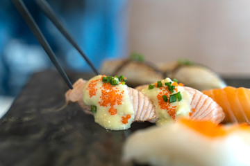 Eating Sushi with chopsticks. Fresh sushi japanese food in restaurant.