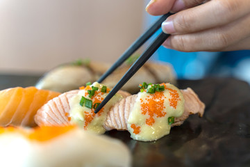 Eating Sushi with chopsticks. Fresh sushi japanese food in restaurant.