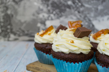Chocolate cupcakes with vanilla butter frosting and golden crumbs, chocolate, and lemon. There is a memo for the text.