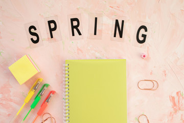 SPRING word on a student desk workspace. Flat lay, top view, header template.