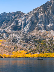 Tranquil autumn scene with a fishing boat on the lake