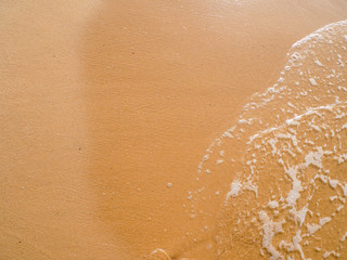 Background image sand on the beach and wave with foam