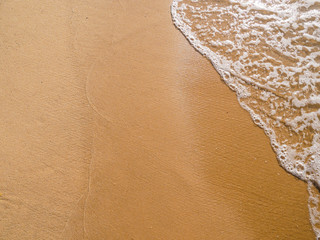 Background image sand on the beach and wave with foam