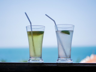 two glasses of cocktail standing against the sky