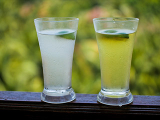 two glasses of cocktail standing on a green background