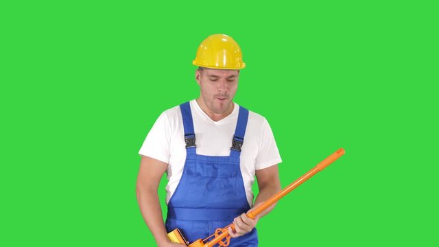 Cheerful man playing on the swob like it is a guitar on a Green Screen, Chroma Key.
