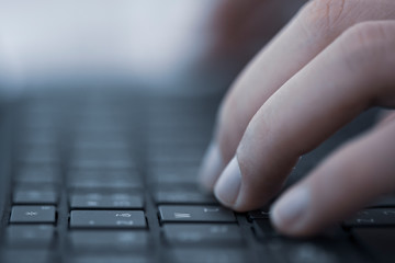 キーボードに触れる人の手
