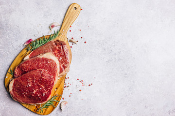 Fresh raw Black Angus beef steak on wooden board