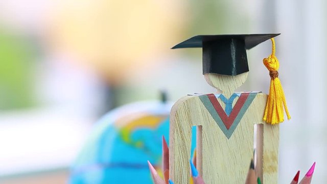 Graduation cap and pencils on blur earth globe models background, alternative studying distant for learn. Graduate or Education knowledge learning study abroad concept, Back to School and successful