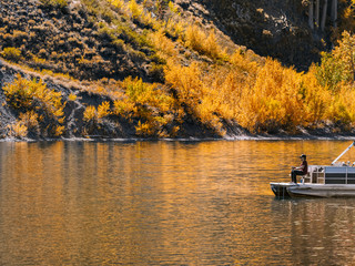 Stunning autumn landscape with fisherman on a mountain lake