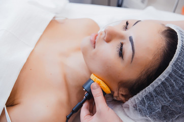 Skin Care. Microcurrent therapy. Beautiful young girl on the procedures for skin care. Hardware cosmetology. Cleaning of the face skin in the spa