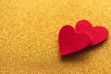 Red felt hearts on golden shiny background. Valentine's Day