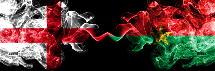 Obraz premium English vs Burkina Faso smoky mystic flags placed side by side. Thick colored silky smokes flag of England and Burkina Faso.
