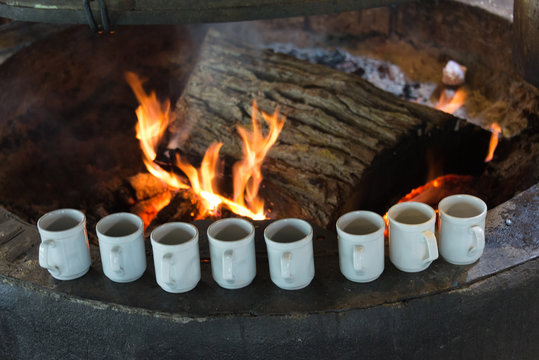 Multiple White Coffee Mugs Close To A Fireplace At Las Cotorras Restaurant, Tierra Del Fuego, Argentina. 