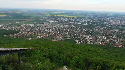 Obraz premium View of center of Nitra city, western Slovakia, from Zobor hill located above the city, cloudy spring day, remains of aircable landing zone in right bottom corner