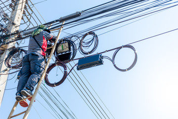 Technician man install cabinet on fiber optic cable system.