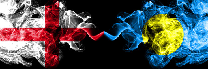 English vs Palau, Palaulan smoky mystic flags placed side by side. Thick colored silky smokes flag of England and Palau, Palaulan.