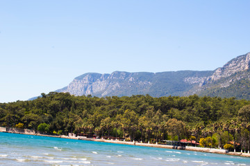 Fototapeta na wymiar Mountains covered with green trees and azure sea