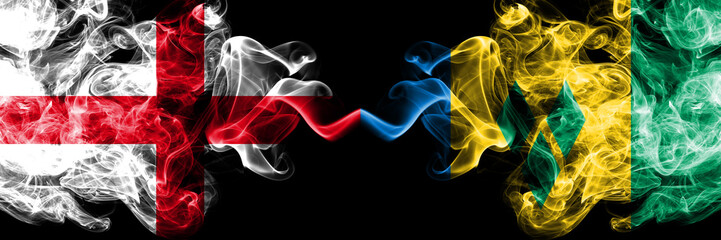 English vs Saint Vincent and the Grenadines smoky mystic flags placed side by side. Thick colored silky smokes flag of England and Saint Vincent and the Grenadines.
