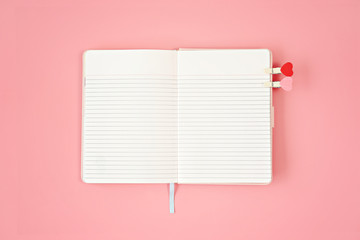Blank open notebook on pink background