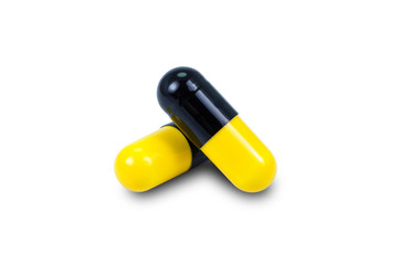 Yellow and black capsule medicine pill isolated on white background.