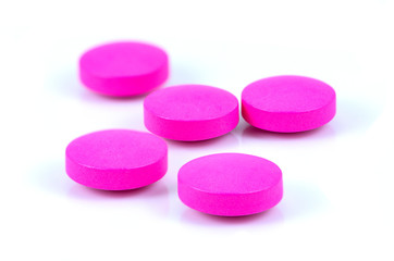 Closeup pink medicine pills isolated on white background.