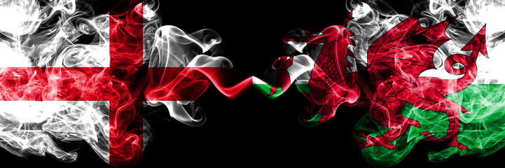 English vs Wales, Welsh smoky mystic flags placed side by side. Thick colored silky smokes flag of England and Wales, Welsh.