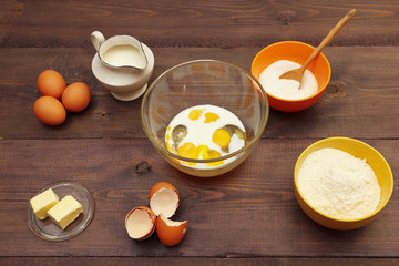 Natural ingredients for making dough for baking on a wooden table.