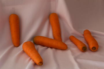 Group of beautiful carrots on a white fabric background