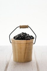 Coffee beans in a small wooden bucket