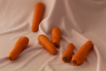 Group of beautiful carrots on a white fabric background