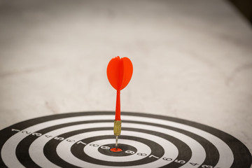 Red dart arrow hitting in the target center of dartboard on bullseye with sun light vintage style, Target marketing and business success concept - Image.