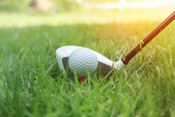 Golf ball and golf club in beautiful golf course at Thailand. Collection of golf equipment resting on green grass with green background
