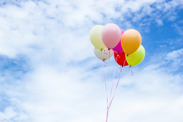 Fototapeta na wymiar Colorful group balloons with a background of clouds and sky beautiful.
