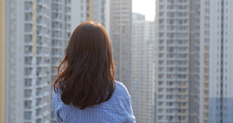 Woman look at the city with building at sunset time