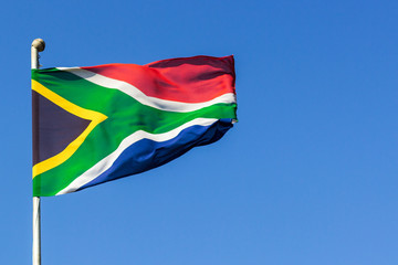 South African flag blowing in the wind with clear blue sky